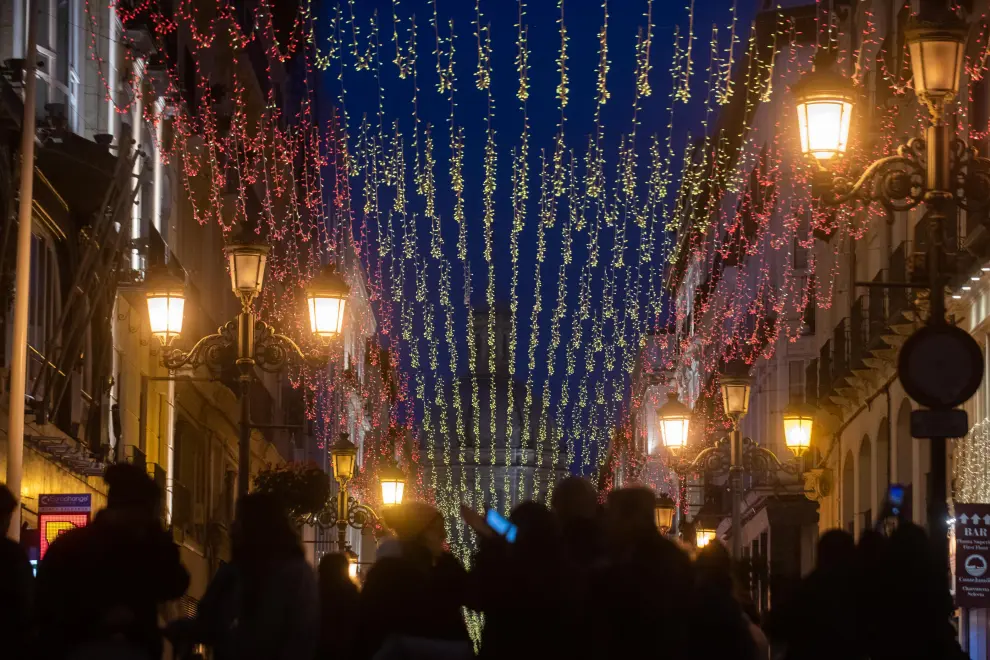 Los ciudadanos abarrotan la calle de Alfonso, que luce las luces de Navidad con los colores de la bandera de España, este miércoles.
