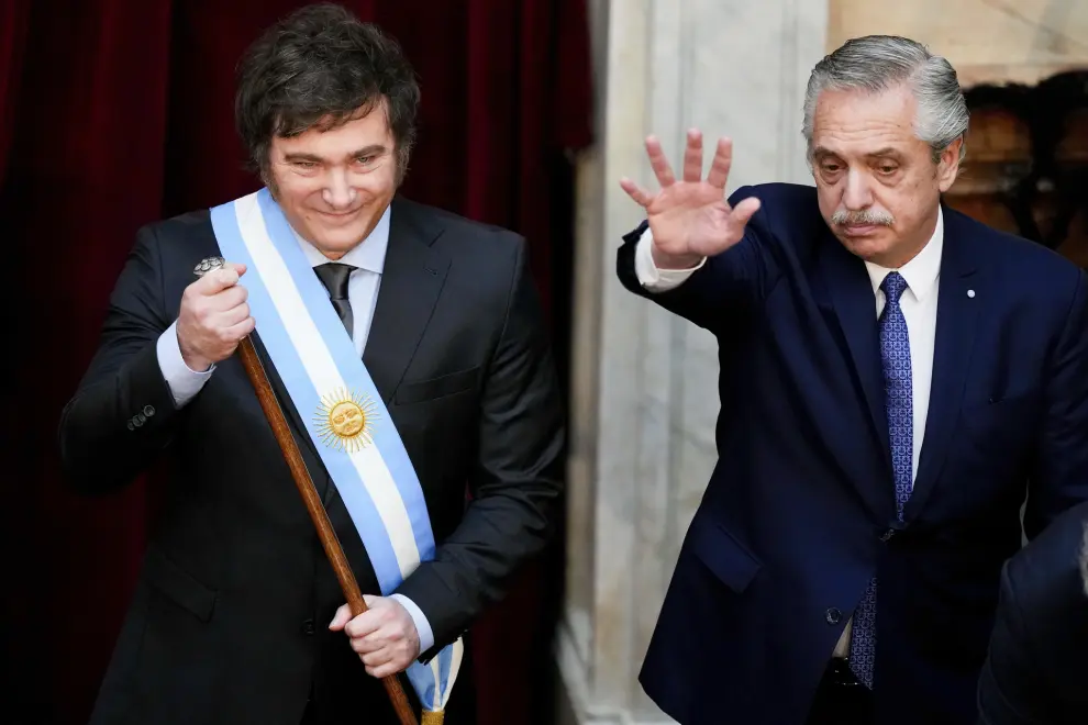 Argentina's incoming President Javier Milei holds the presidential cane after receiving it from outgoing President Alberto Fernandez, right, at the Congress in Buenos Aires, Argentina, Sunday, Dec. 10, 2023. (AP Photo/Natacha Pisarenko)