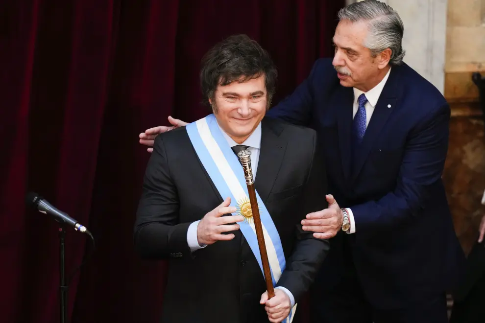 Argentina's outgoing President Alberto Fernandez pats incoming President Javier Milei after handing him the presidential sash at the Congress in Buenos Aires, Argentina, Sunday, Dec. 10, 2023. (AP Photo/Natacha Pisarenko)