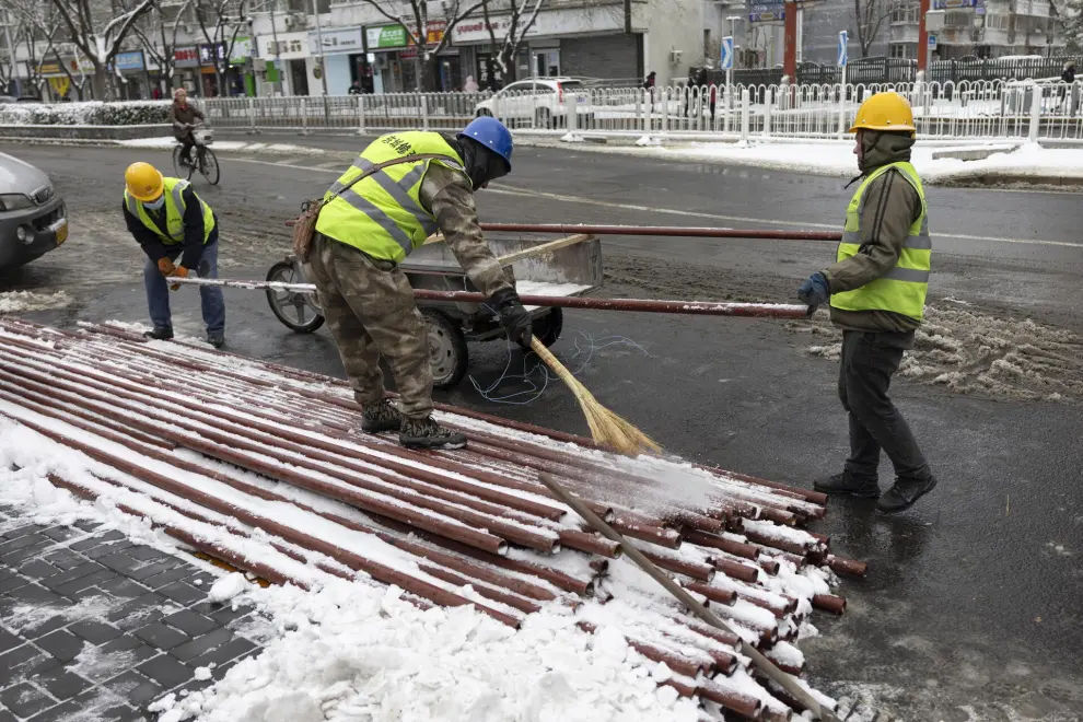 Beijing (China), 11/12/2023.- Workers prepare to load metal tubes for a construction site in Beijing, China, 11 December 2023. Beijing has its first snowfall this winter as in the northern regions, China'Äôs Meteorological service has issued a yellow alert for blizzards. EFE/EPA/ANDRES MARTINEZ CASARES
