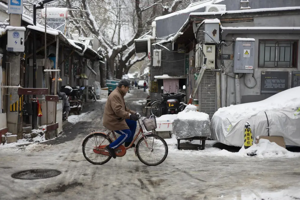 Beijing (China), 11/12/2023.- A man rides a bicycle along a street covered in snow in Beijing, China, 11 December 2023. Beijing has its first snowfall this winter as in the northern regions, China'Äôs Meteorological service has issued a yellow alert for blizzards. EFE/EPA/ANDRES MARTINEZ CASARES