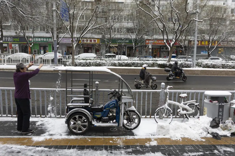 Beijing (China), 11/12/2023.- A man removes snow from a tricycle in Beijing, China, 11 December 2023. Beijing has its first snowfall this winter as in the northern regions, China'Äôs Meteorological service has issued a yellow alert for blizzards. EFE/EPA/ANDRES MARTINEZ CASARES
