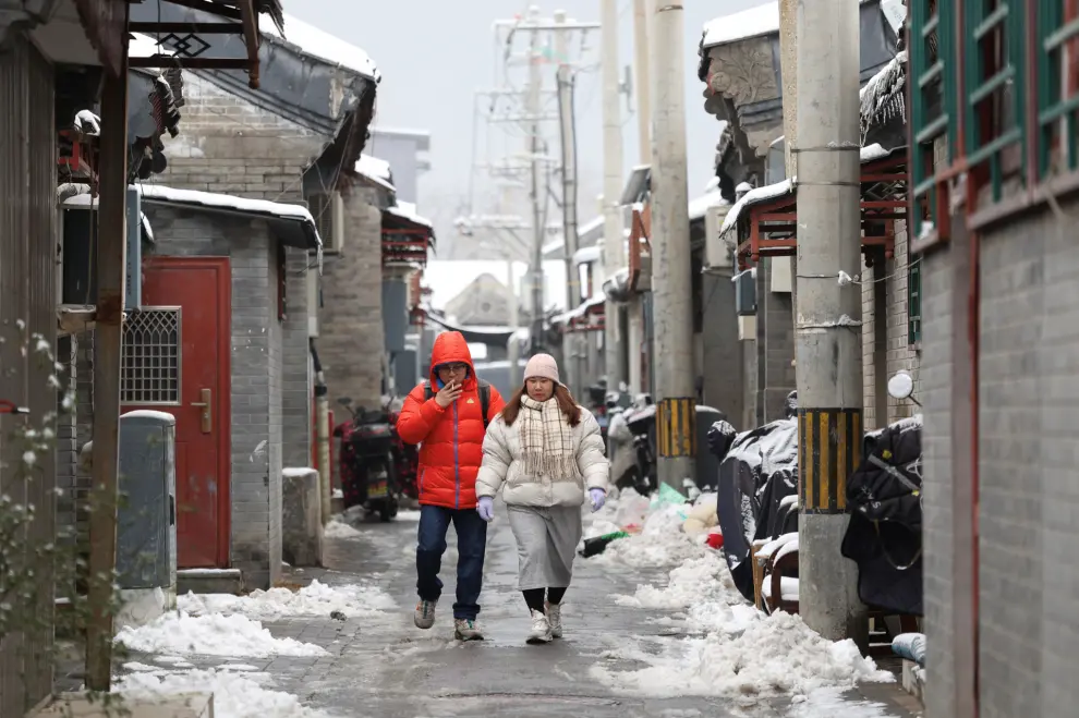 People walk in a hutong alley on a snowy day in Beijing, China December 11, 2023. REUTERS/Tingshu Wang [[[REUTERS VOCENTO]]]