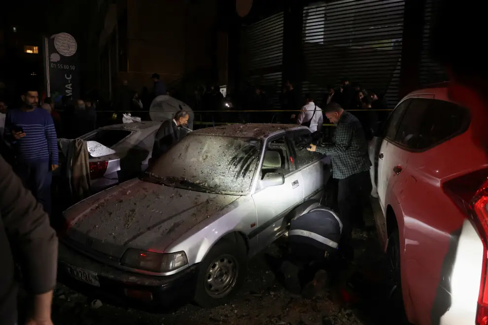 People gather near a damaged car following an explosion, in what security sources say is an Israeli drone strike, at the Beirut suburb of Dahiyeh, Lebanon January 2, 2024. REUTERS/Mohamed Azakir [[[REUTERS VOCENTO]]]