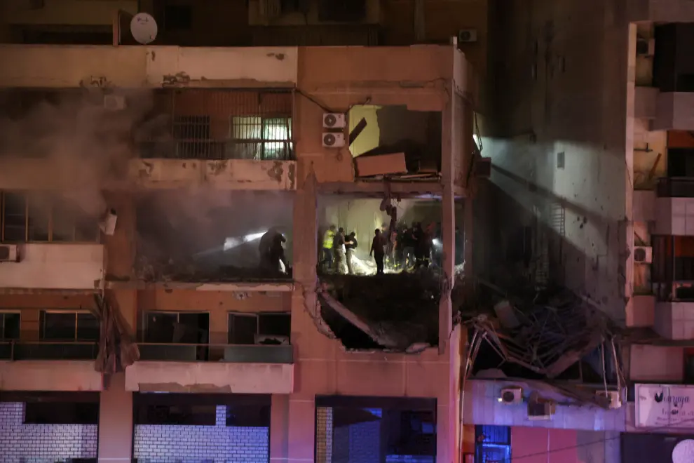 People stand at a damaged building following an explosion, in what security sources say is an Israeli drone strike, at the Beirut suburb of Dahiyeh, Lebanon January 2, 2024. REUTERS/Mohamed Azakir [[[REUTERS VOCENTO]]]