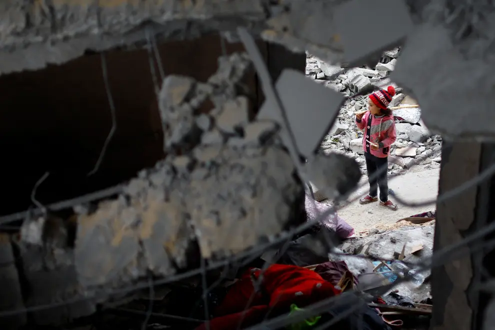 Un niño palestino inspecciona una casa dañada en un bombardeo israelí.