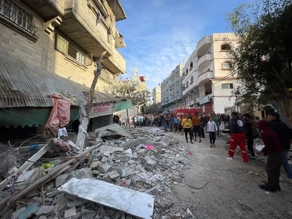 Varios palestinos buscan entre los escombros tras un bombardeo en un campo de refugiados en el centro de Gaza.