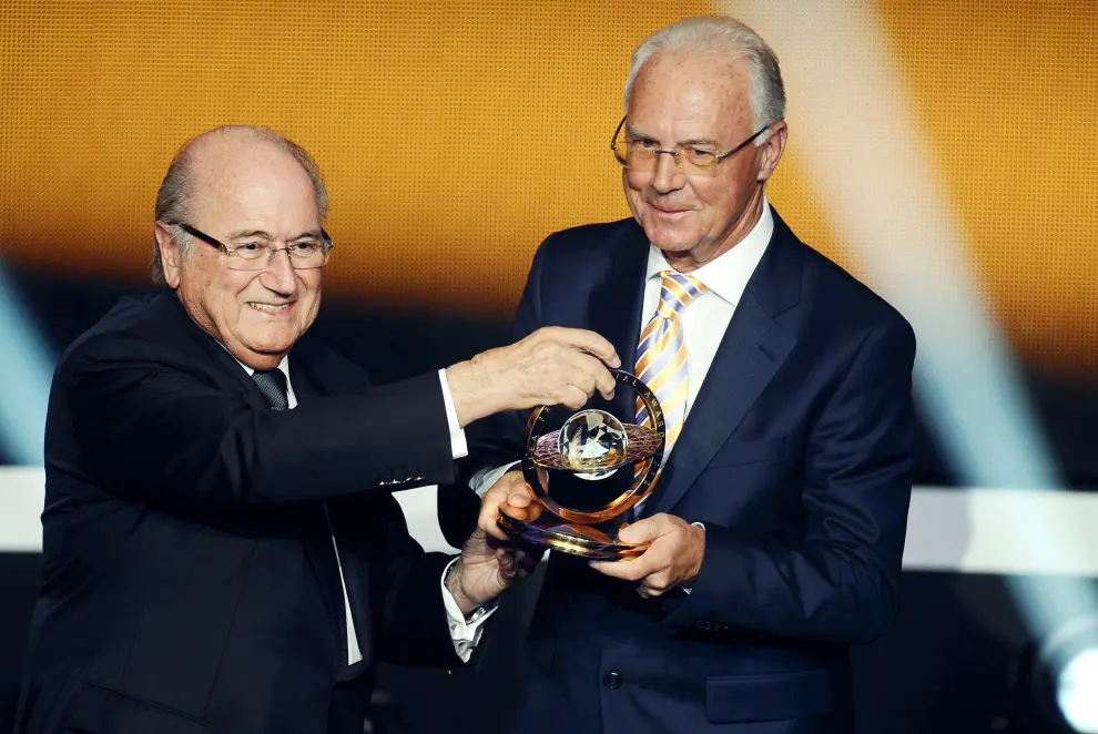 Una fotografía de archivo de la ex leyenda del fútbol alemán Franz Beckenbauer (derecha) posando con el trofeo después de recibir el Premio Presidencial de la FIFA de manos del Presidente de la FIFA Joseph S. Blatter, en la gala del Balón de Oro 2012
