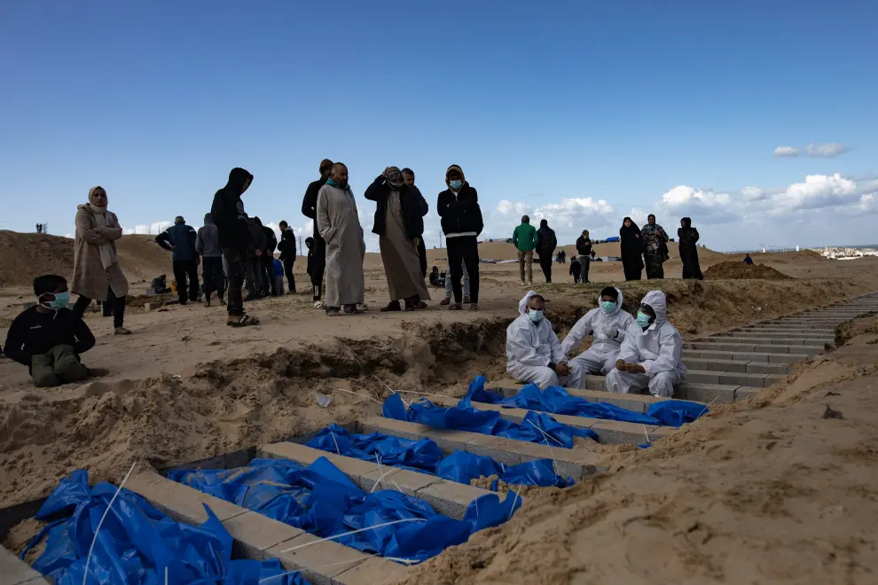 Trabajadores del Ministerio de Sanidad palestino preparan cadáveres para un entierro masivo en el campo de Rafah, al sur de la Franja de Gaza