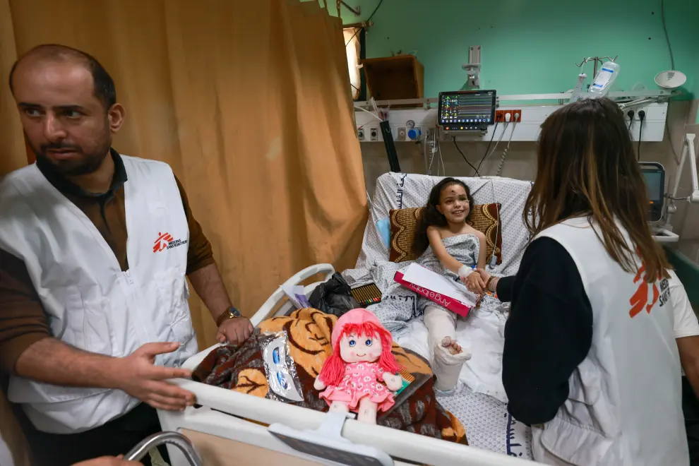Abdalla Salem (left) is an MSF psychologist at Al Aqsa Hospital. Razan Samer Shabet, the young girl, lost her whole family in the bombing while she was injured. She has been in the hospital ever since. A distant uncle looks after her. She doesn't know her family have been killed.