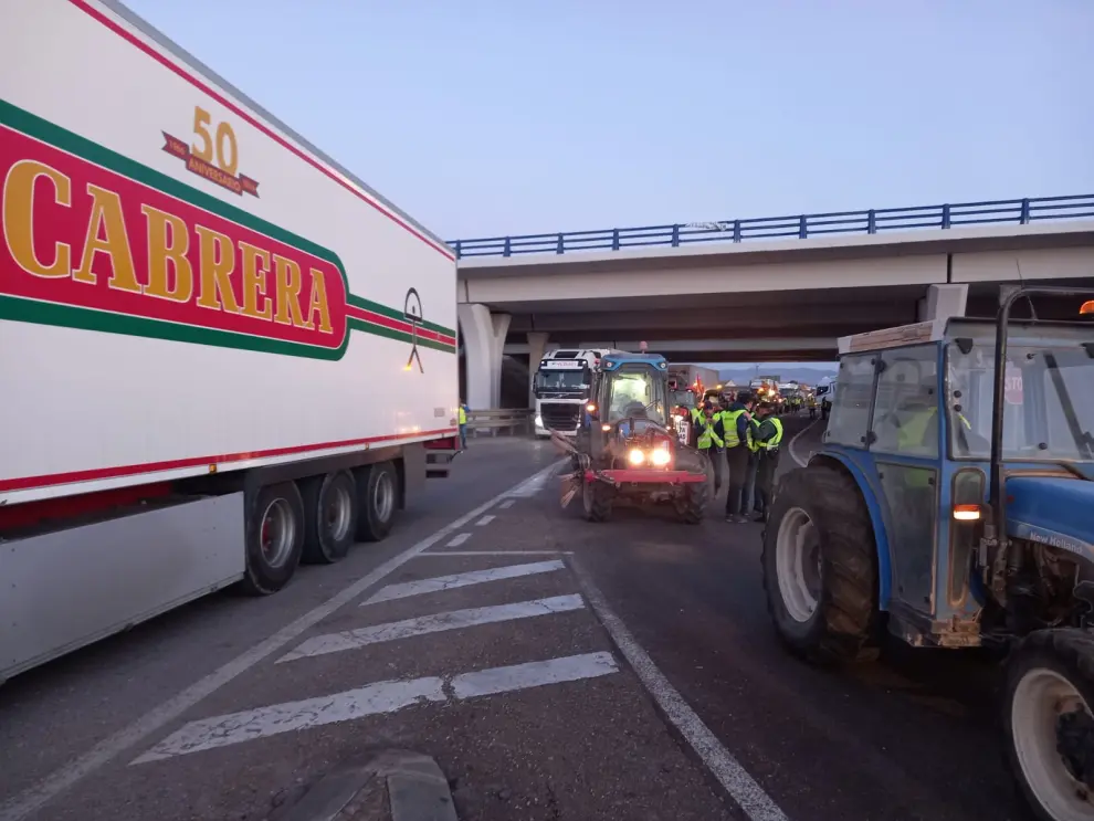 Los tractores bloquean la rotonda de enlace entre la A220 y la A122, con varios camiones detenido en La Almunia de Doña Godina.