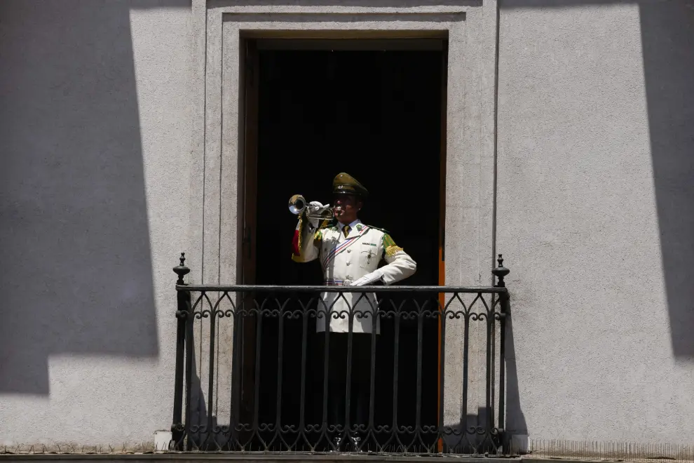 A police officer plays the trumpet  at La Moneda presidential palace during the state funeral for former Chilean President Sebastian Pinera in Santiago, Chile, Friday, Feb. 9, 2024. The two-time former president died on Feb. 6 in a helicopter crash. He was 74. (AP Photo/Esteban Felix)