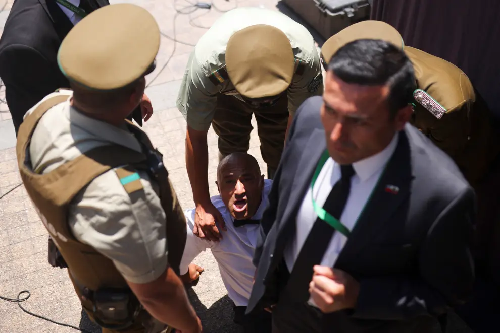 Carabineros de Chile police officers detain a man, who tried to approach Chiles President Gabriel Boric with a briefcase, during a funeral event for Chiles former President Sebastian Pinera, at the presidential palace La Moneda in Santiago, Chile February 9, 2024. REUTERS/Pablo Sanhueza [[[REUTERS VOCENTO]]]