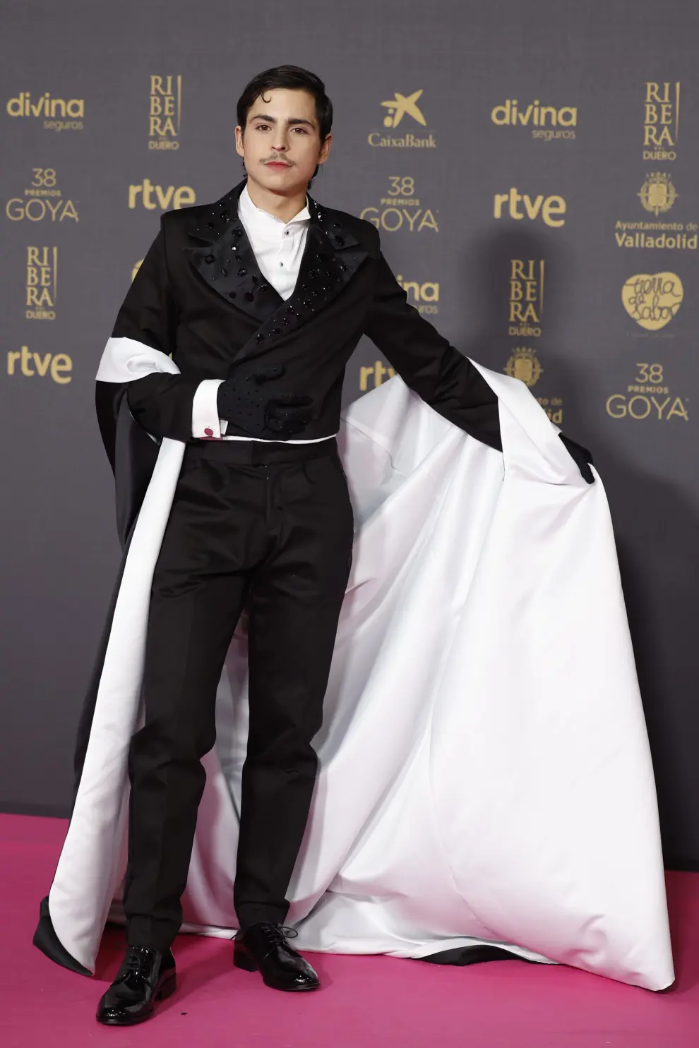 El actor Omar Banana posa con un traje con capa en blanco y negro