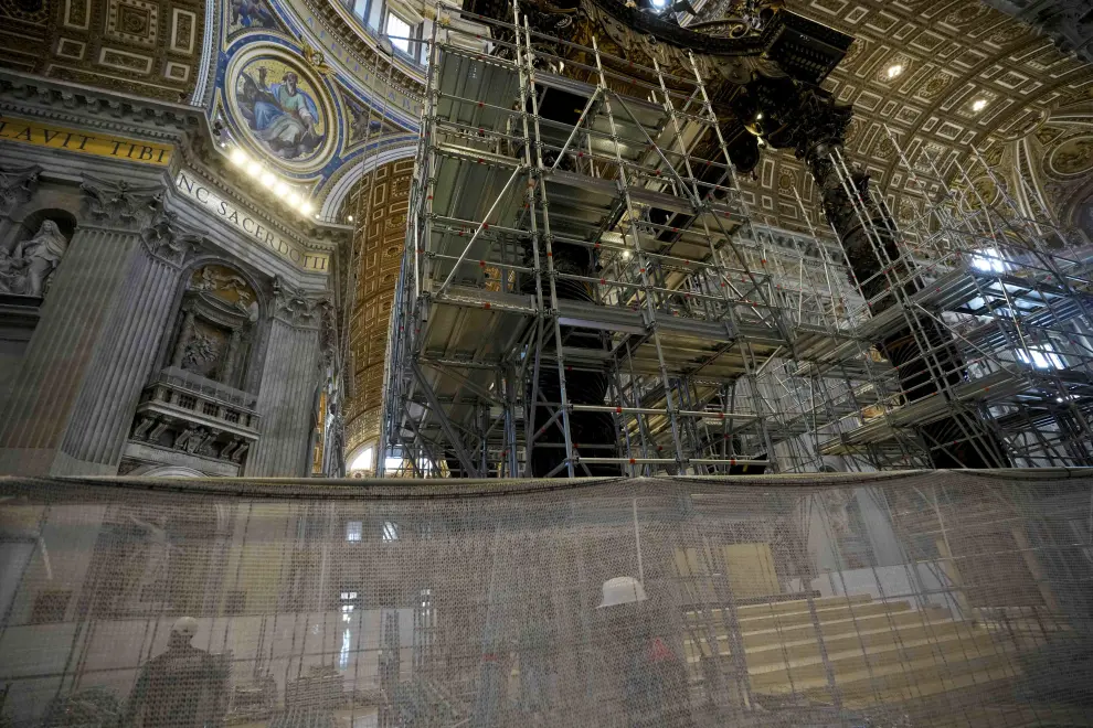 A woman takes photos in front of the scaffolding surrounded 17th century, 95ft-tall bronze canopy by Giovan Lorenzo Bernini surmounting the papal Altar of the Confession in St. Peters Basilica at the Vatican, Wednesday, Feb. 21, 2024. Works have started for year-long, 700,000 euro restoration of the monumental baldacchino, or canopy, of St. Peters Basilica, pledging to complete the first comprehensive work on Berninis masterpiece in 250 years before Pope Francis big 2025 Jubilee. (AP Photo/Andrew Medichini)..Associated Press/LaPresse.Only Italy and Spain [[[AP/LAPRESSE]]]