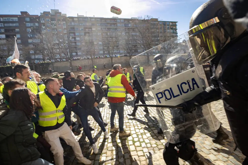 ZARAGOZA, 01/03/2024.- Un grupo de agricultores intenta romper el cordón policial en los alrededores del Palacio de La Aljafería, sede de las Cortes de Aragón, este viernes en Zaragoza. EFE/ Javier Belver