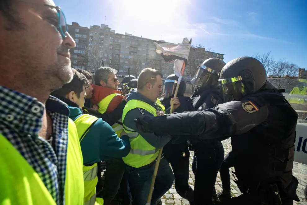 ZARAGOZA, 01/03/2024.- Un grupo de agricultores intenta romper el cordón policial en los alrededores del Palacio de La Aljafería, sede de las Cortes de Aragón, este viernes en Zaragoza. EFE/ Javier Belver