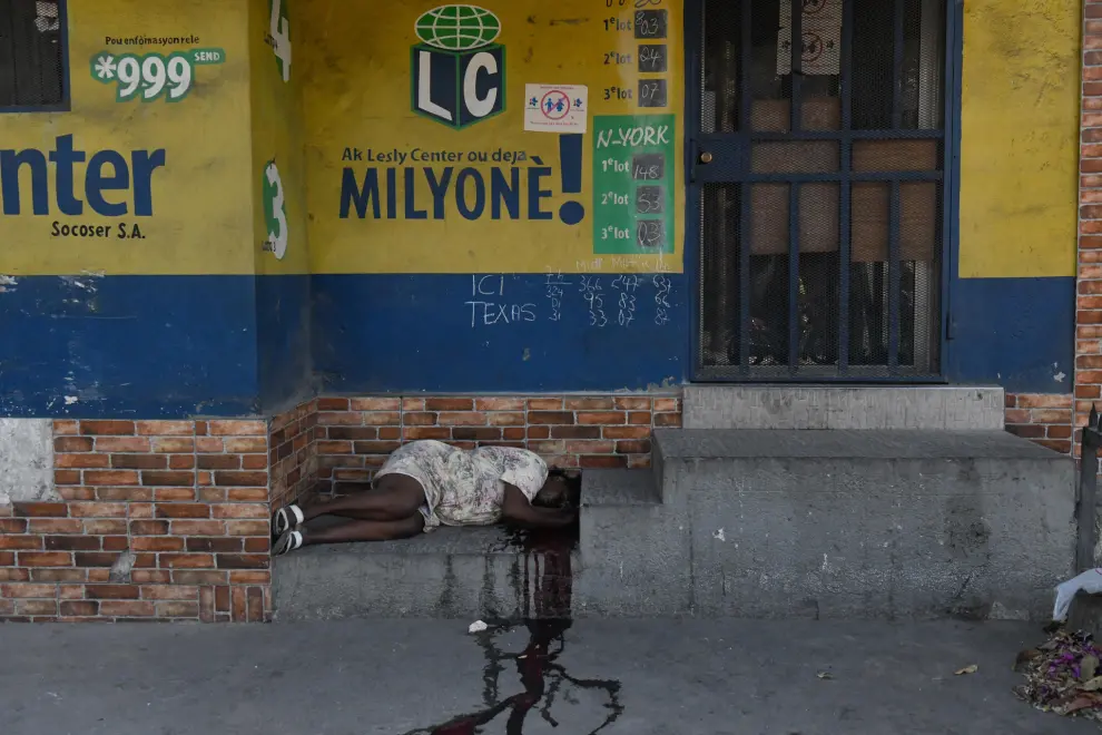ATENCIÓN EDITORES: CONTENIDO GRÁFICO EXPLÍCITO - AME9715. PUERTO PRÍNCIPE (HAITÍ), 18/03/2024.- Fotografía del cadáver de una mujer en el suelo en una calle este lunes, en Puerto Príncipe (Haití). Doce cadáveres fueron encontrados este lunes en Petion-Ville, en las colinas de Puerto Príncipe, en circunstancias aún por aclarar, como la identidad de las víctimas, que no se descarta sean miembros de bandas armadas abatidos por la Policía Nacional. Los cuerpos, entre ellos el de una mujer, fueron hallados dispersos en plena vía, en los alrededores de una zona dedicada al comercio informal de alimentos y otros productos. EFE/ Johnson Sabin
