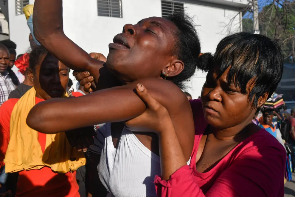 AME9715. PUERTO PRÍNCIPE (HAITÍ), 18/03/2024.- Una mujer reacciona luego de ver el cadáver de un familiar en la calle este lunes, en Puerto Príncipe (Haití). Doce cadáveres fueron encontrados este lunes en Petion-Ville, en las colinas de Puerto Príncipe, en circunstancias aún por aclarar, como la identidad de las víctimas, que no se descarta sean miembros de bandas armadas abatidos por la Policía Nacional. Los cuerpos, entre ellos el de una mujer, fueron hallados dispersos en plena vía, en los alrededores de una zona dedicada al comercio informal de alimentos y otros productos. EFE/ Johnson Sabin
