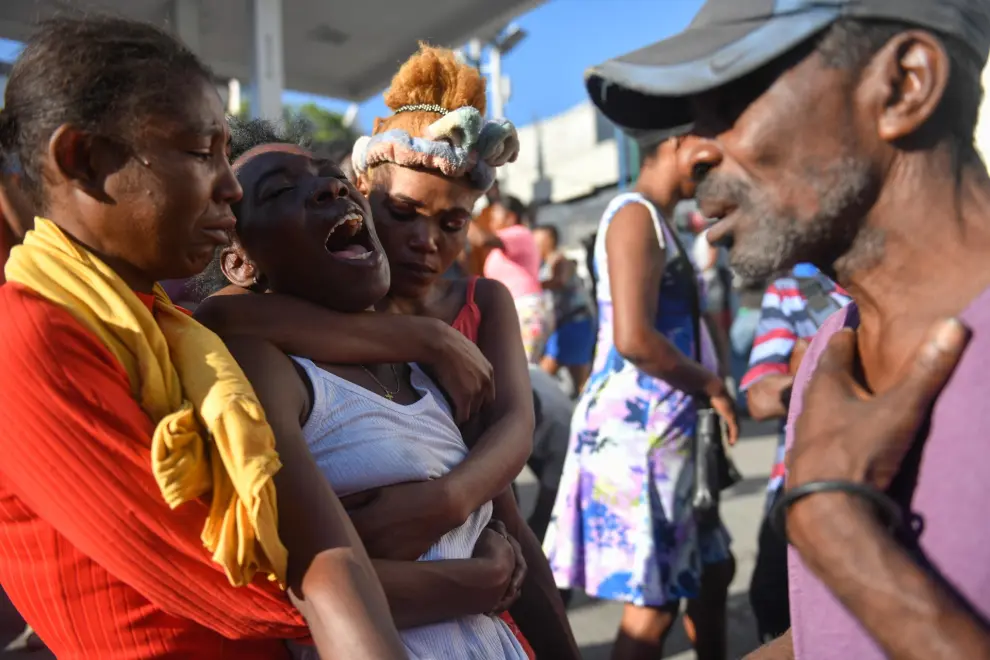 AME9715. PUERTO PRÍNCIPE (HAITÍ), 18/03/2024.- Una mujer reacciona luego de ver el cadáver de un familiar en la calle este lunes, en Puerto Príncipe (Haití). Doce cadáveres fueron encontrados este lunes en Petion-Ville, en las colinas de Puerto Príncipe, en circunstancias aún por aclarar, como la identidad de las víctimas, que no se descarta sean miembros de bandas armadas abatidos por la Policía Nacional. Los cuerpos, entre ellos el de una mujer, fueron hallados dispersos en plena vía, en los alrededores de una zona dedicada al comercio informal de alimentos y otros productos. EFE/ Johnson Sabin
