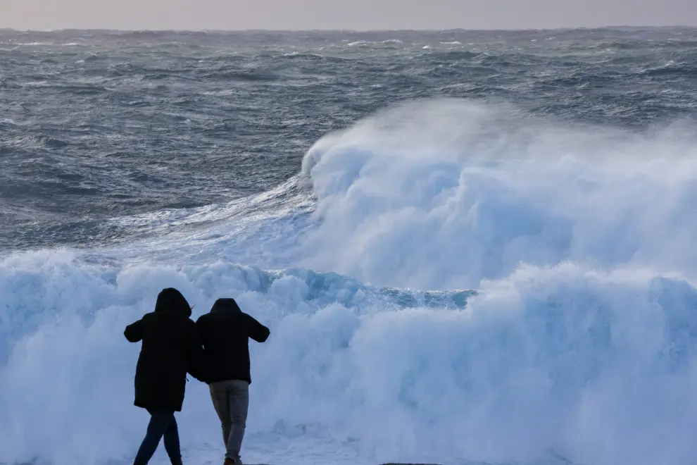 Dos turistas observan el oleaje en la costa de Muxía (Galicia), donde estos días festivos están marcados por la borrasca Nelson.