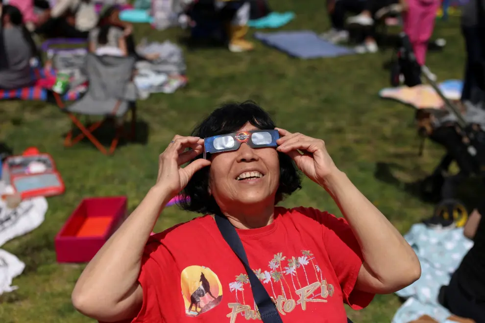 Una mujer prueba sus gafas protectoras en el eclipse solar, en el Salón de Ciencias de Nueva York