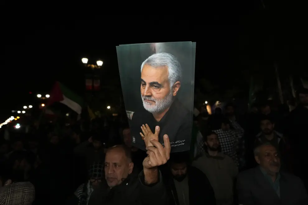Un manifestante festeja el ataque contra Israel enfrente de la embajada británica en Teherán. Sostiene una imagen de un miembro de la Guardia Revolucionaria Iraní, Qassem Soleimani, muerto en un ataque con drones estadounidense en 2020.