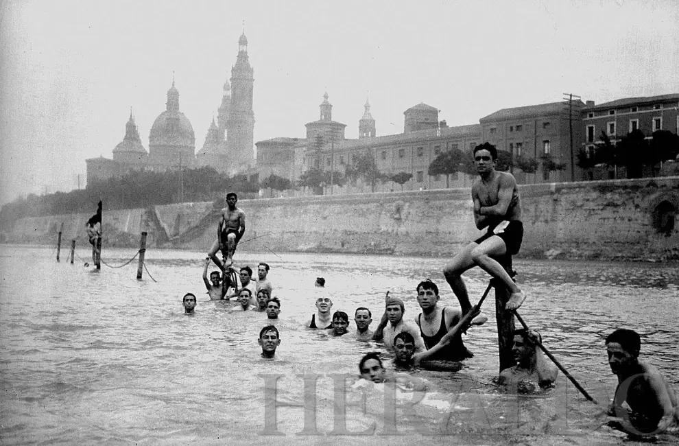 Gente bañándose en el límite de las aguas del río Ebro destinada a los baños públicos en los años 20.