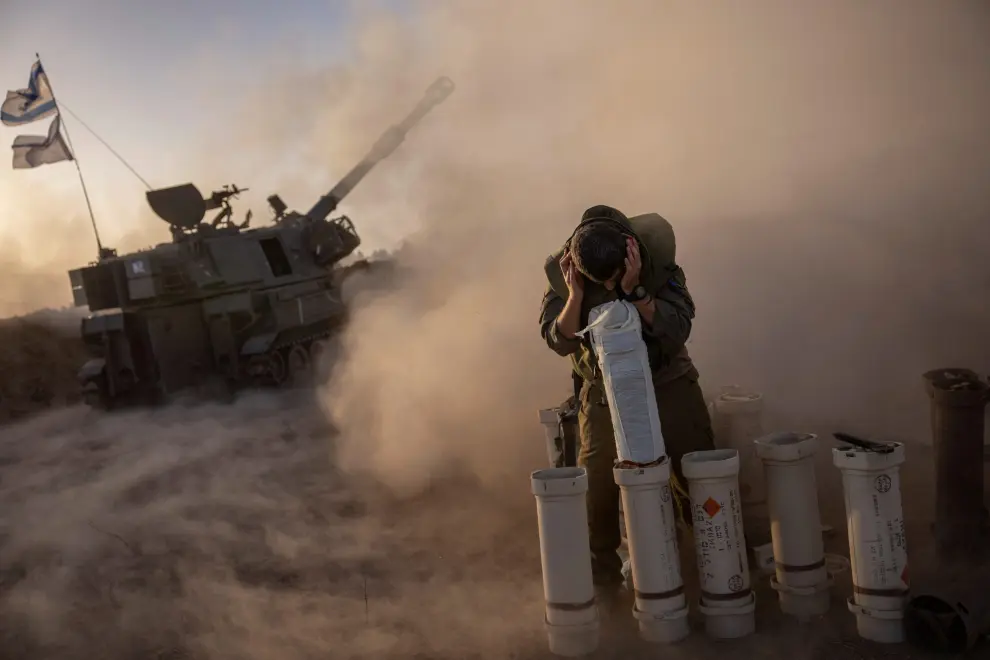 Un soldado se cubre mientras una unidad de artillería móvil dispara proyectiles de 155 mm contra Gaza desde Netivot, Israel, en medio del conflicto entre Israel y Hamás, el 6 de noviembre de 2023