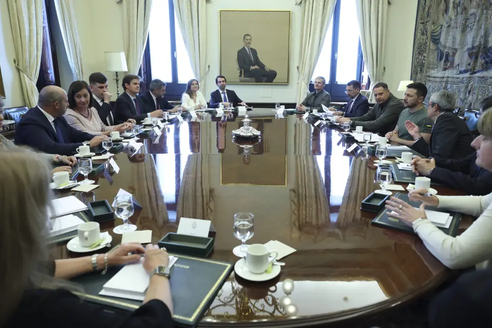 El presidente ucraniano, Volodímir Zelenski (c), firma el libro de visitas en el Congreso de los Diputados antes de su reunión con la presidenta del Congreso, Francina Armengol