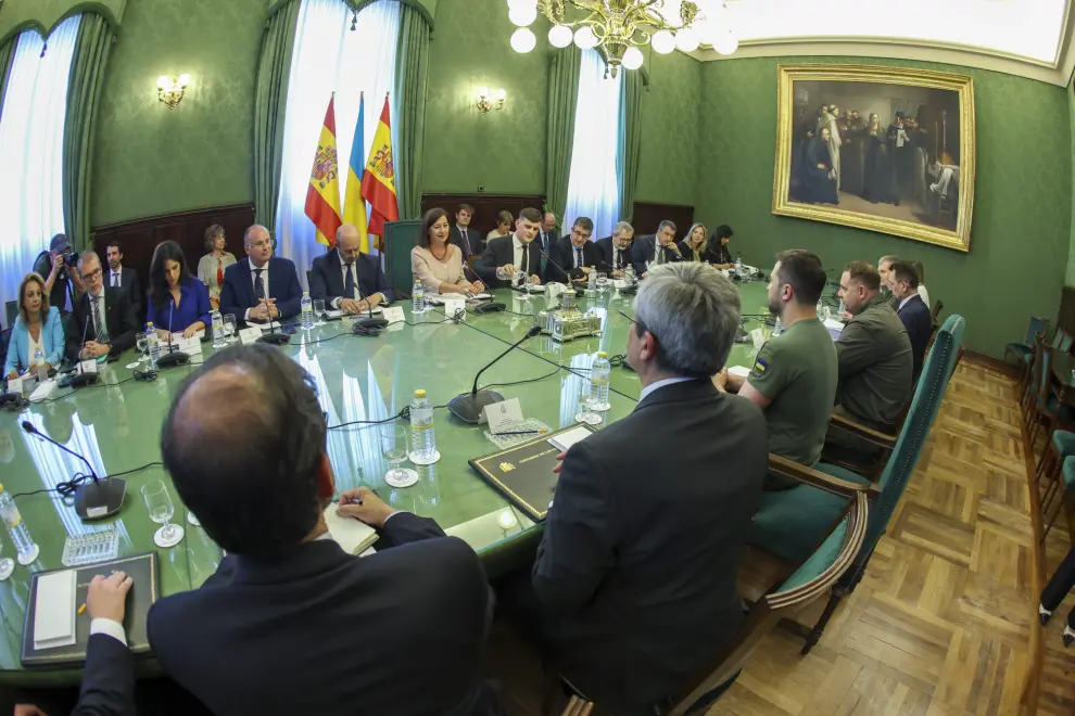 El presidente ucraniano, Volodímir Zelenski (c), firma el libro de visitas en el Congreso de los Diputados antes de su reunión con la presidenta del Congreso, Francina Armengol