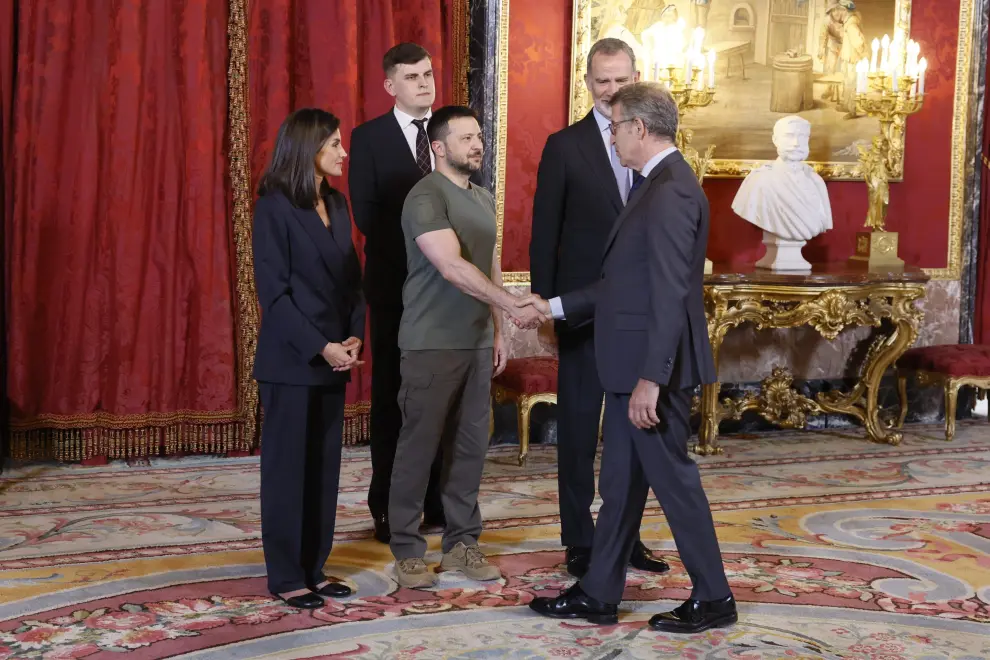 El rey Felipe VI, junto al presidente de Ucrania, Volodímir Zelenski (izda) saludan al líder del PP, Alberto Núñez Feijóo, a su llegada al almuerzo ofrecido en el Palacio Real