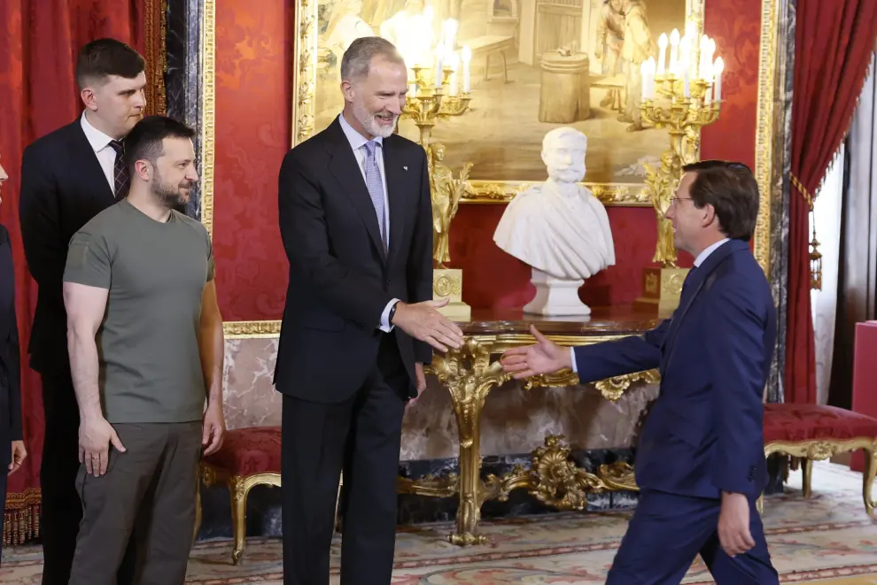 El rey Felipe VI, junto al presidente de Ucrania, Volodímir Zelenski (izda) saludan  al alcalde de Madrid, José Luis Martínez-Almeida, a su llegada al almuerzo ofrecido en el Palacio Real