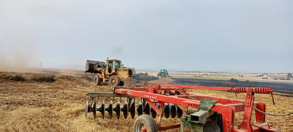 Labores de extinción de un incendio en un campo que estaban cosechando en Peralta de Alcofea.