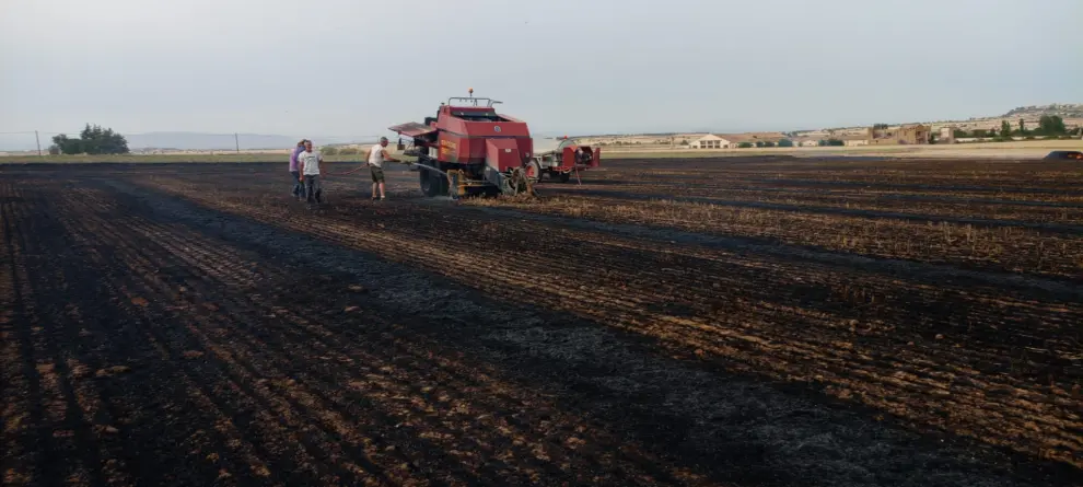 Labores de extinción de un incendio en un campo que estaban cosechando en Peralta de Alcofea.