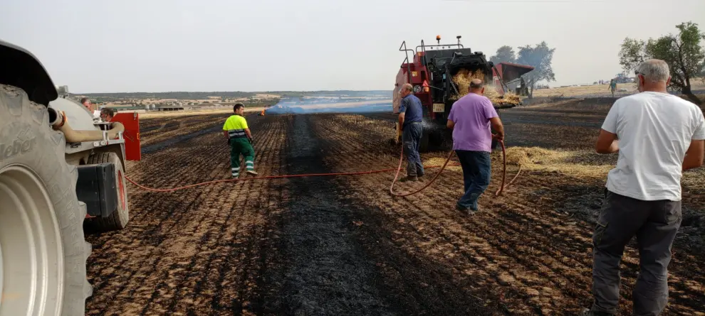 Labores de extinción de un incendio en un campo que estaban cosechando en Peralta de Alcofea.