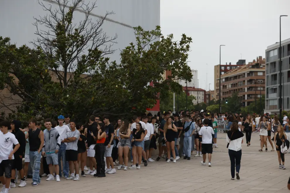 Filas de personas aguardan para entrar al concierto de Eladio Carrión en el pabellón Príncipe Felipe, en Zaragoza