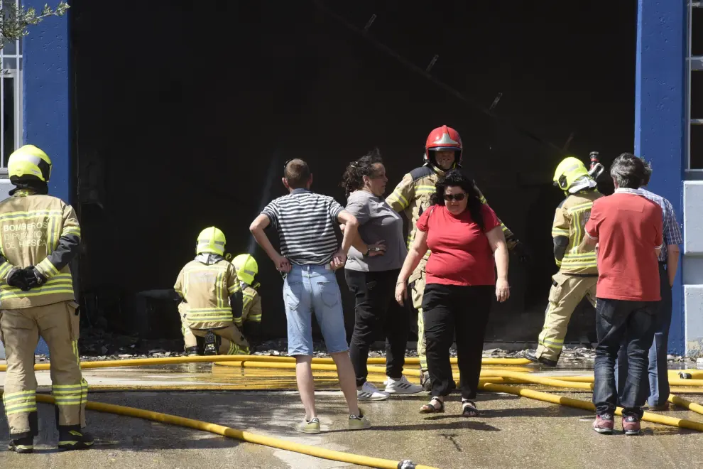 Varias dotaciones de bomberos trabajan en la extinción de un virulento incendio que ha destruido dos naves en el polígono Monzú de Huesca, una de ellas de residuos y otra de construcción.