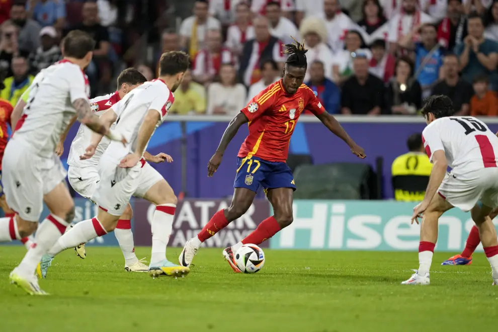 Spain's Nico Williams controls the ball next to Georgia players during a round of sixteen match between Spain and Georgia at the Euro 2024 soccer tournament in Cologne, Germany, Sunday, June 30, 2024. (AP Photo/Darko Vojinovic)