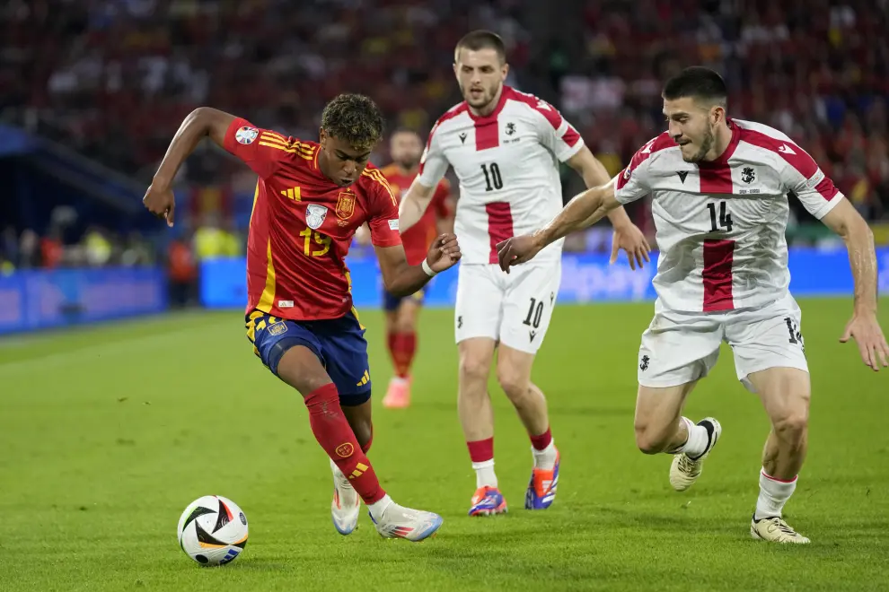 Spain's Lamine Yamal fights for the ball against Georgia's Luka Lochoshvili during a round of sixteen match between Spain and Georgia at the Euro 2024 soccer tournament in Cologne, Germany, Sunday, June 30, 2024. (AP Photo/Darko Vojinovic)