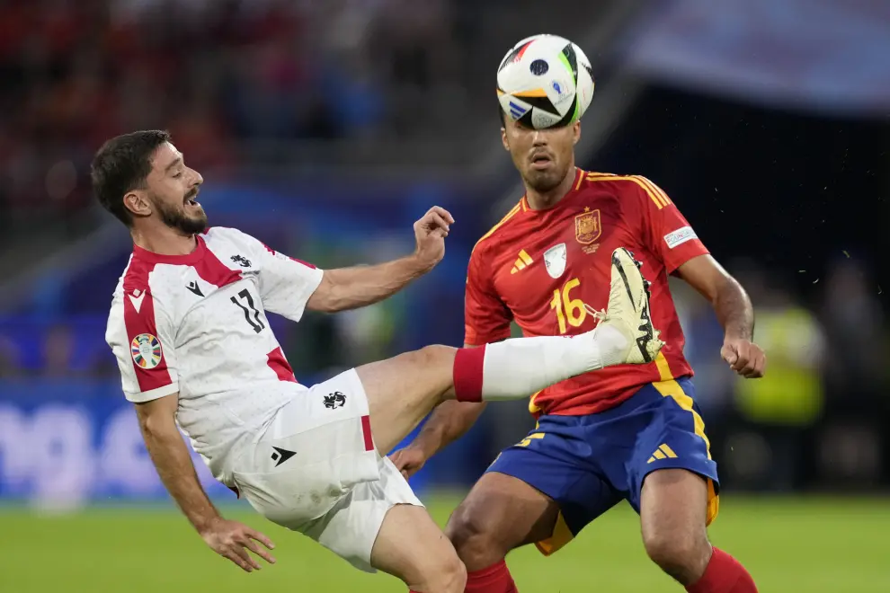 Georgia's Otar Kiteishvili fights for the ball against Spain's Rodri during a round of sixteen match between Spain and Georgia at the Euro 2024 soccer tournament in Cologne, Germany, Sunday, June 30, 2024. (AP Photo/Darko Vojinovic)