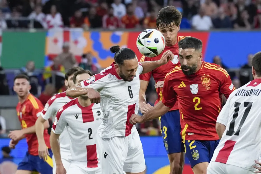 Spain's Dani Carvajal, right, heads the ball against Georgia's Giorgi Kochorashvili (6) during a round of sixteen match between Spain and Georgia at the Euro 2024 soccer tournament in Cologne, Germany, Sunday, June 30, 2024. (AP Photo/Martin Meissner)