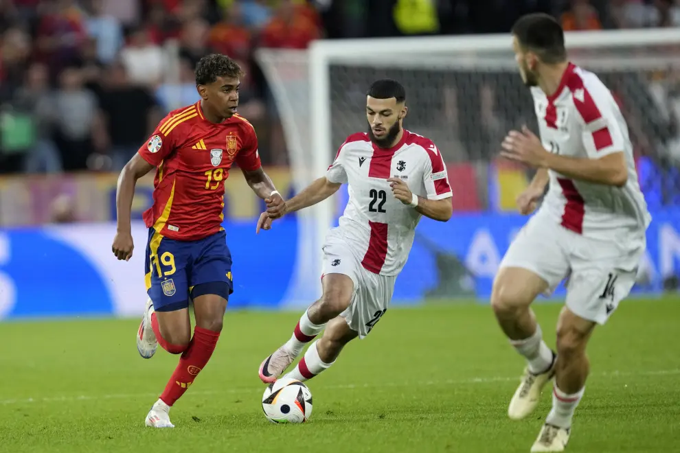 Spain's Lamine Yamal fights for the ball against Georgia's Georges Mikautadze during a round of sixteen match between Spain and Georgia at the Euro 2024 soccer tournament in Cologne, Germany, Sunday, June 30, 2024. (AP Photo/Darko Vojinovic)