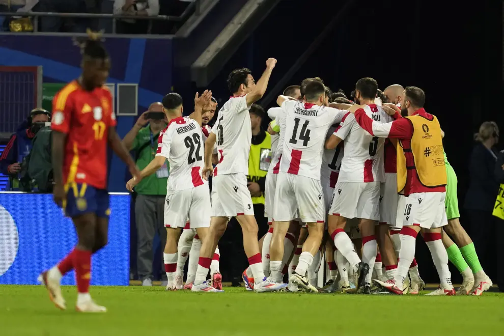 Georgia's Khvicha Kvaratskhelia celebrates with team mates after scoring the opening goal during a round of sixteen match between Spain and Georgia at the Euro 2024 soccer tournament in Cologne, Germany, Sunday, June 30, 2024. (AP Photo/Darko Vojinovic)