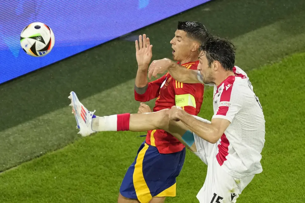 Georgia's Giorgi Gvelesiani, right, challenges for the ball with Spain's Alvaro Morata during a round of sixteen match between Spain and Georgia at the Euro 2024 soccer tournament in Cologne, Germany, Sunday, June 30, 2024. (AP Photo/Andreea Alexandru)