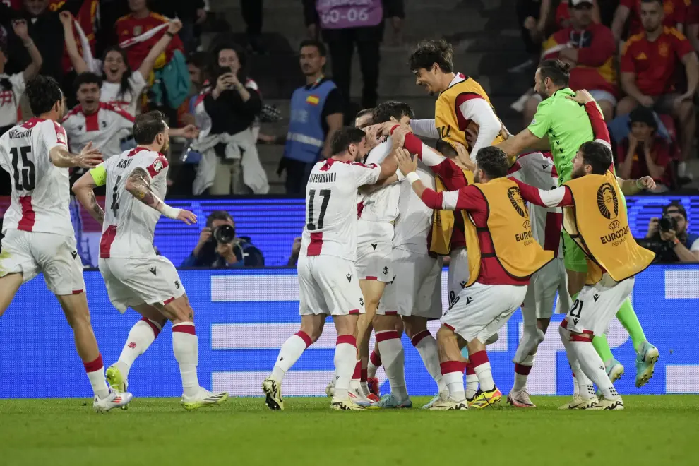 Georgia players celebrate after an own goal by Spain's Robin Le Normand during a round of sixteen match between Spain and Georgia at the Euro 2024 soccer tournament in Cologne, Germany, Sunday, June 30, 2024. (AP Photo/Martin Meissner)