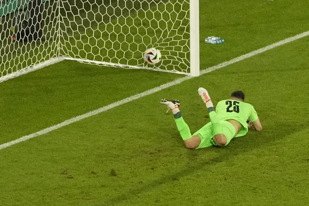 Georgia's goalkeeper Giorgi Mamardashvili dives but fails to save the goal from Spain's Rodri during a round of sixteen match between Spain and Georgia at the Euro 2024 soccer tournament in Cologne, Germany, Sunday, June 30, 2024. (AP Photo/Andreea Alexandru)