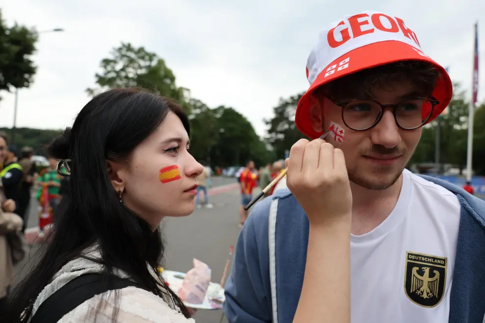 Cologne (Germany), 30/06/2024.- A supporter of Spain (L) draws a flag on the face of a supporter of Georgia as they arrive for the UEFA EURO 2024 Round of 16 soccer match between Spain and Georgia, in Cologne, Germany, 30 June 2024. (Alemania, España, Colonia) EFE/EPA/MOHAMED MESSARA

