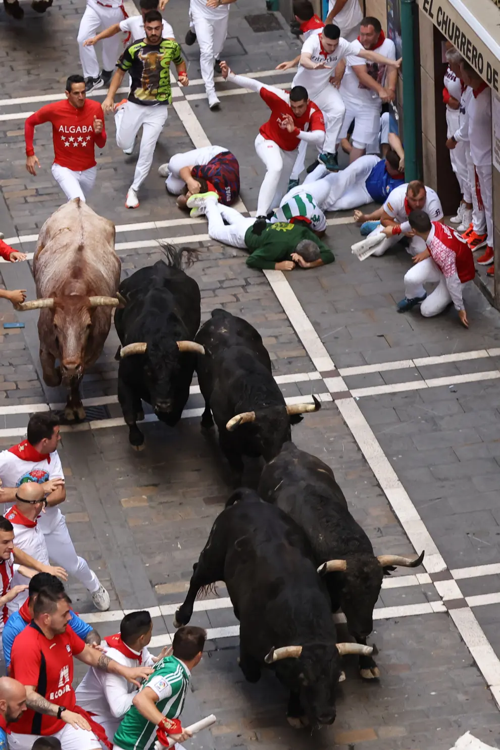 PAMPLONA, 12/07/2024.- Los mozos son perseguidos por toros de la ganadería de Jandilla, de Mérida (Badajoz), durante el sexto encierro de los Sanfermines 2024, este viernes en Pamplona. EFE/J.P. Urdiroz
