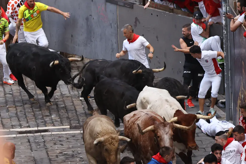PAMPLONA, 12/07/2024.- Los mozos son perseguidos por toros de la ganadería de Jandilla, de Mérida (Badajoz), durante el sexto encierro de los Sanfermines 2024, este viernes en Pamplona. EFE/J.P. Urdiroz
